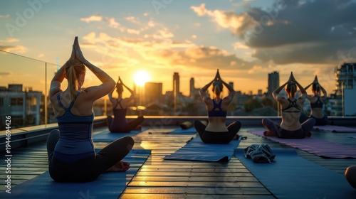 Group women practicing yoga at rooftop during sunrise