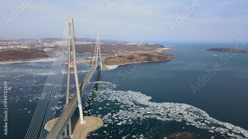 Cable-stayed Russky Bridge in Vladivostok, Russia, connecting Russky Island with the mainland over the Eastern Bosphorus Strait. Winter view with sea partially covered with ice.
