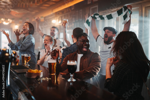 Diverse group of friends cheering sports at a bar
