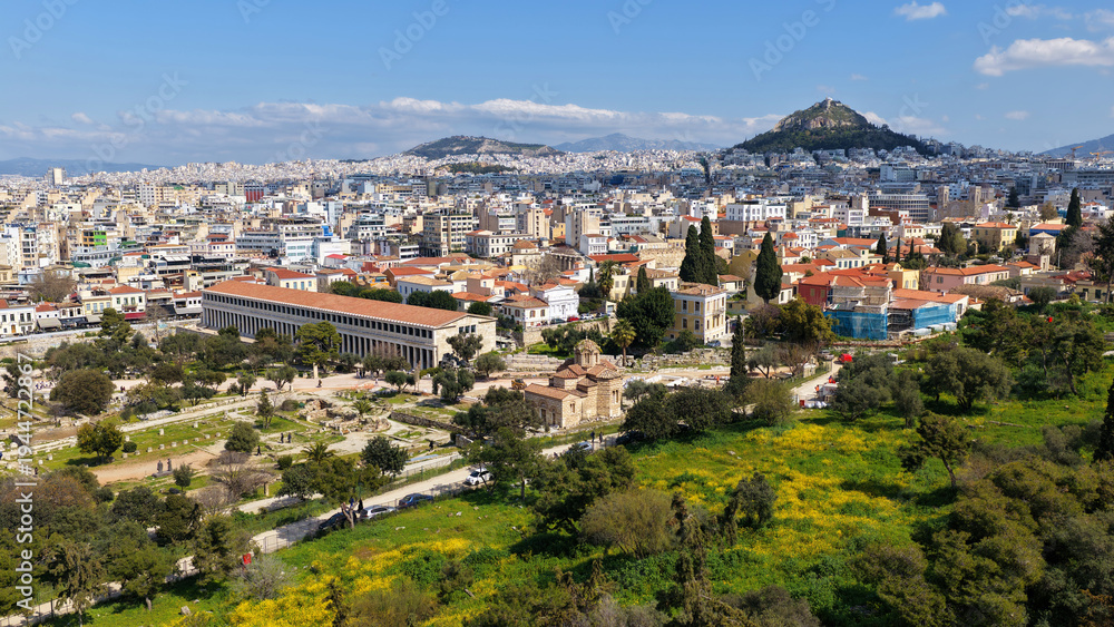 Fototapeta premium Aerial drone portrait photo of ancient Roman Market featuring tower of Winds and Gate of Athena in the heart of Athens historic centre built in Plaka district, below Acropolis hill, Attica, Greece