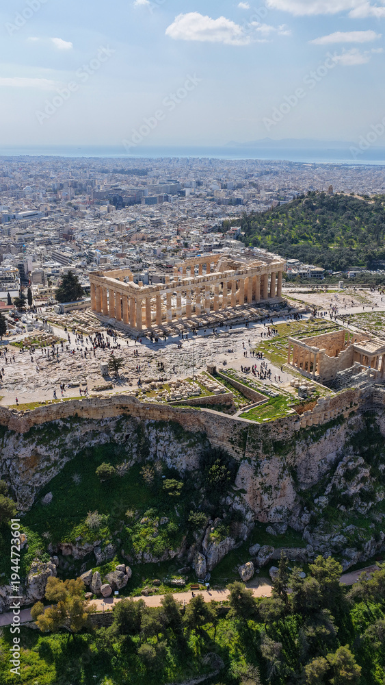 Fototapeta premium Aerial drone photo above Acropolis hill and the Parthenon featuring Propylaea and porch of the Caryatids, Athens historic centre, Attica, Greece
