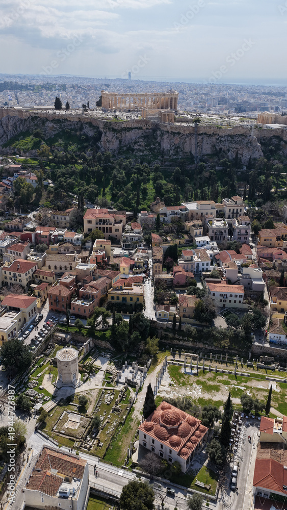 Naklejka premium Aerial drone portrait photo of ancient Roman Market featuring tower of Winds and Gate of Athena in the heart of Athens historic centre built in Plaka district, below Acropolis hill, Attica, Greece