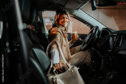 Fotografija Woman entering car with coffee cup, placing handbag, starting daily commute and