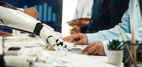 Bild auf Leinwand A robot and human team collaborate in a modern office setting, analyzing data and charts for strategic decision-making, showcasing the future of work
