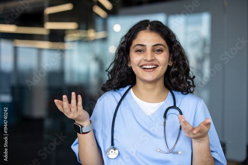 Slika na platnu Young indian female medical professional in blue scrubs and stethoscope smiling,