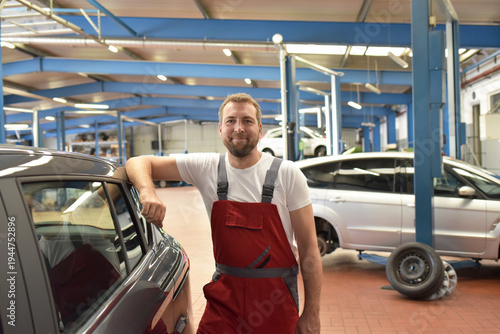 Portrait of a smiling car mechanic in a professional workshop - closeup photo