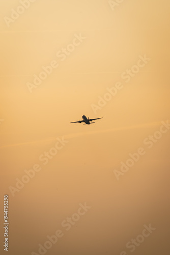 An airplane takes off into the sunset
