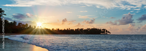 Paradise beach sunset landscape with tropical palm trees silhouettes.