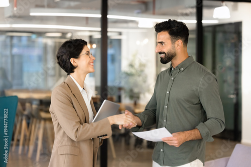 Canvas Print Two multiethnic businesspeople shake hands in office