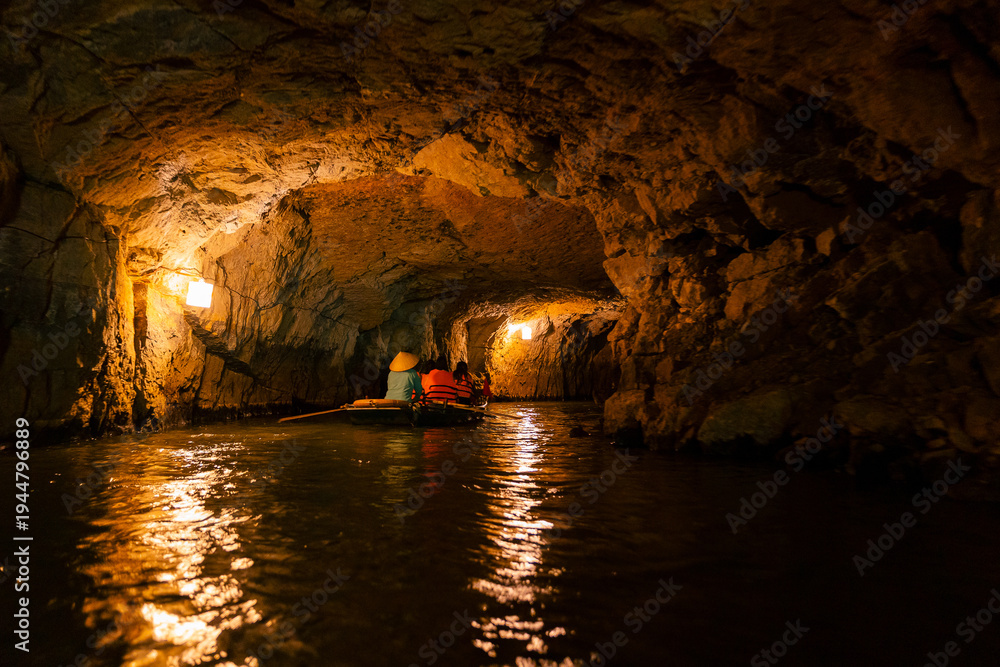 Fototapeta premium Peaceful cave boat ride in Ninh Binh, Vietnam's scenic Tam Coc National Park