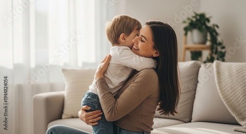 Mother happily hugging her young son on the sofa at home, Mother's Day concept  