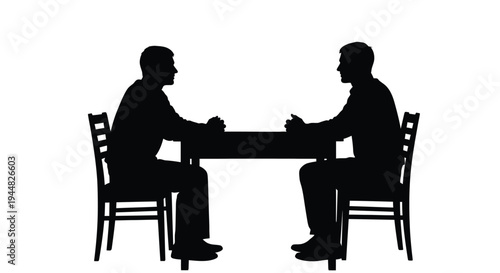 Two men seated at a table in discussion dramatic silhouette
