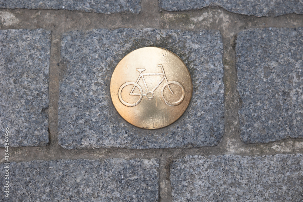 Obraz premium Bicycle path marker on old bruges cobblestone street