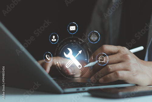 Fotografija Businessman using laptop with digital support service interface, representing IT support, technical maintenance, customer service system, chatbot assistance and technology troubleshooting solutions