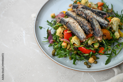 Close up of Greens and Roasted Vegetables Salad Topped with Canned Sardines for Omega-3 and Protein
