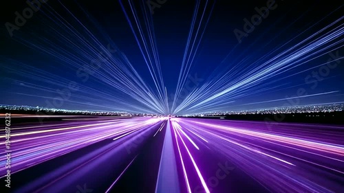 Blurred motion light trails on a road leading to city lights at night