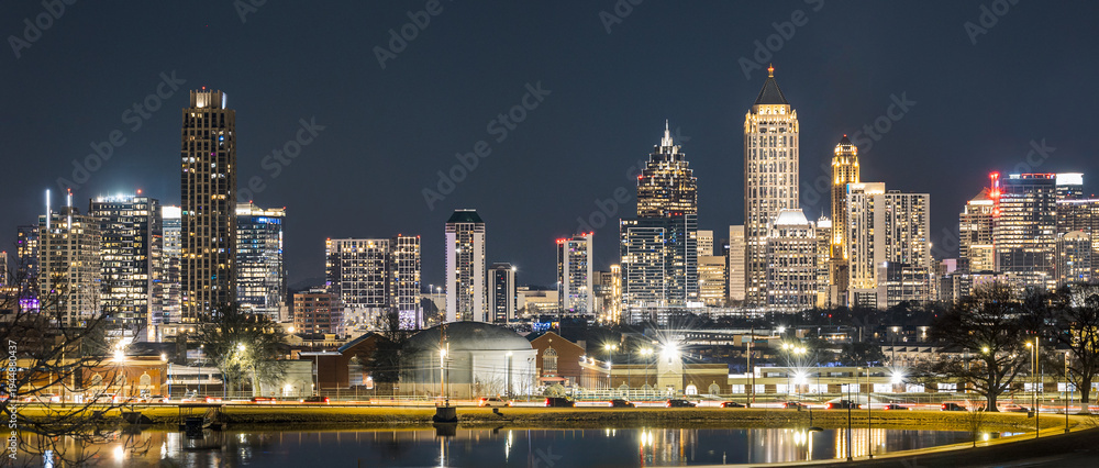 Fototapeta premium View of the Downtown and Midtown Atlanta Skyline Cityscape showing several prominent buildings, highways, cars, and hotels on a beautiful clear night.