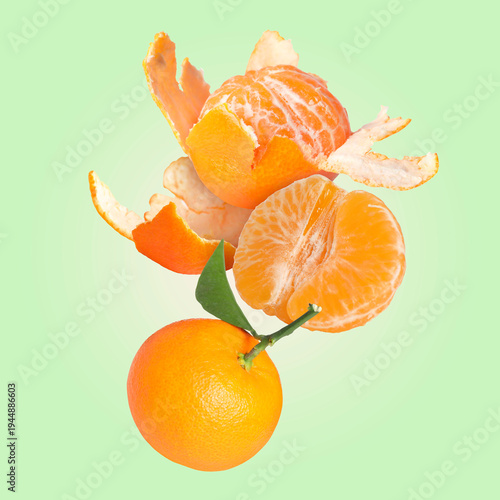 Fresh tangerines falling against pastel green background