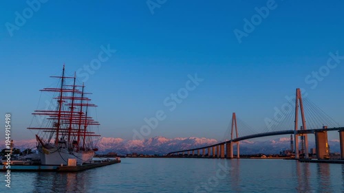夕方の海王丸パークから新湊大橋と海王丸を前景にピンク色染まる立山連峰アーベンロートtimelapse広角