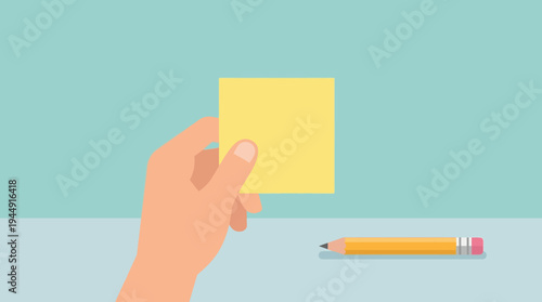 A hand holding a yellow sticky note next to a pencil on a desk