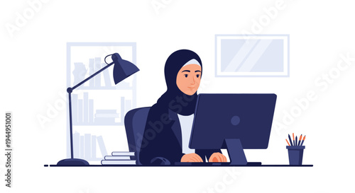 A smiling woman wearing a black hijab and suit jacket is seated at a dark desk, actively working on a desktop computer in an office setting.