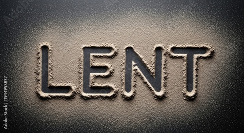 The word 'Lent' written in sand on a dark background.