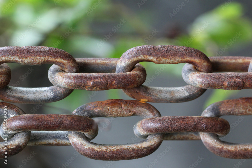 Fototapeta premium Macro view of rusty metal chain links showing natural aging and corrosion, creating an attractive vintage industrial texture suitable for antique wallpaper or background design