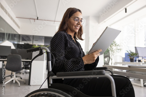 Photos Positive young Middle Eastern female project manager in wheelchair using profess
