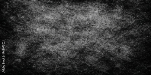 A dark vintage grunge background featuring a textured black and grey concrete wall surface with an aged stone pattern for a rough dirty backdrop design