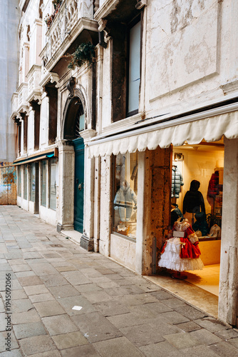 Obraz na płótnie Children explore a shop in a narrow street of Venice during the daytime in autum