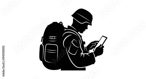 Soldier with Backpack Using Tablet in Silhouette