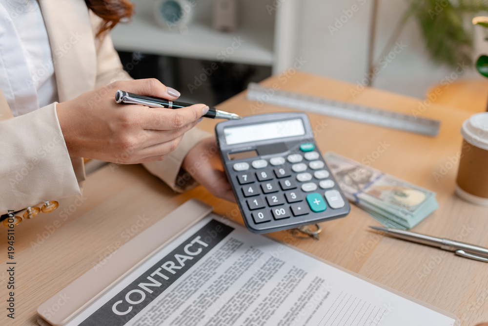 Fototapeta premium A real estate agent and a client are discussing and pointing at a housing contract document during a property purchase meeting, showing agreement details and financial negotiation about home ownership