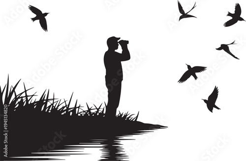 Man in silhouette looking through binoculars at flying birds by water