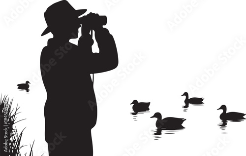 Man in silhouette photographing ducks with binoculars