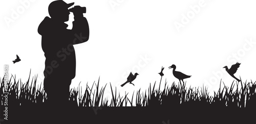 Man in silhouette taking of birds in grass black white