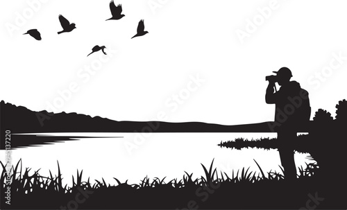 Silhouette of man photographing birds by lake photographer