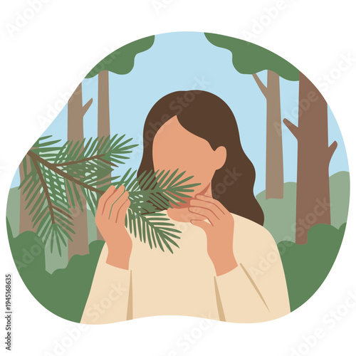 Woman smells leaves in a forest with trees and greenery around her.