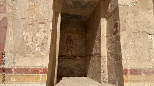 A static shot showing a well-preserved colorful wall painting of an Egyptian pharaoh inside a stone niche at the Temple of Hatshepsut in Luxor
