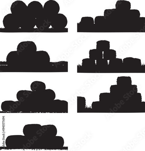 Various stacks of hay bales in different shapes and sizes on grass.