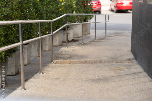 Canvastavla Concrete handicap ramp with staircase metal handrails.
