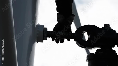 Silhouette hand operating industrial mechanism, valve pipe coupling joint connection. Connecting heavy components for focused, diligent