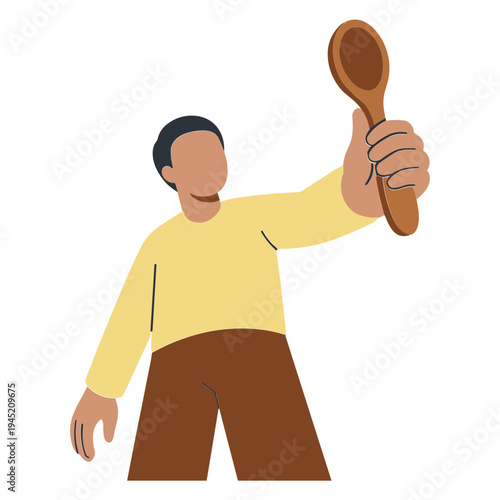 Man holding wooden spoon in hand standing indoors with casual clothes