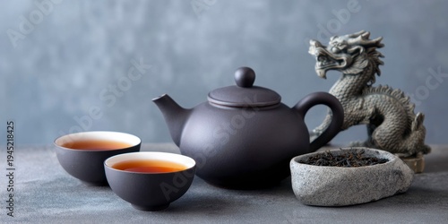 Wallpaper Mural a chinese teapot and two tea cups with loose leaf black tea inside, placed on an elegant dark gray surface Torontodigital.ca