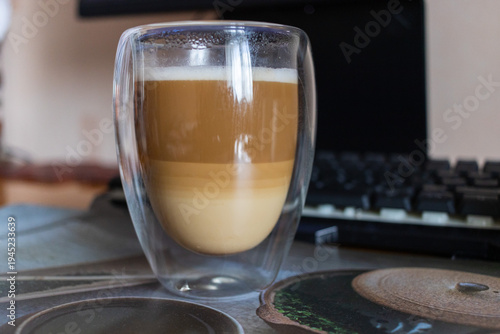 Layered Latte Macchiato in Double Walled Glass on Desk with Mechanical Keyboard