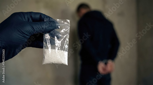 Police evidence bag with seized drugs and handcuffed suspect in background. Narcotics crime and drug trafficking concept. 