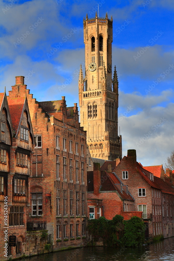 Obraz premium Medieval Belfry Tower Over Canal and Brick Houses in Historic Bruges, Belgium