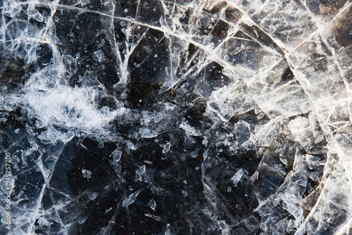 Billede på lærred Cracked ice close-up. Frozen water, ice on brown paving stones