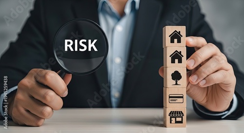 Businessman assessing risk with magnifying glass and wooden block tower