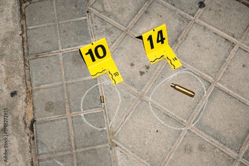 Evidence markers on pavement at crime scene with bullet casings