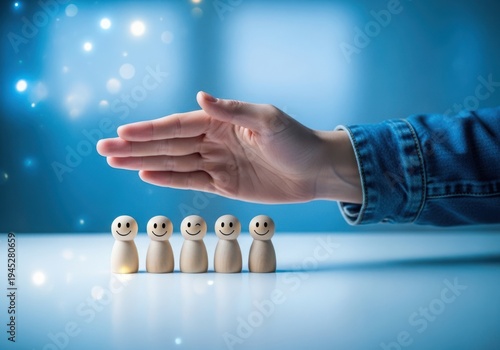 Hand protecting a group of small wooden people figurines on a blue background